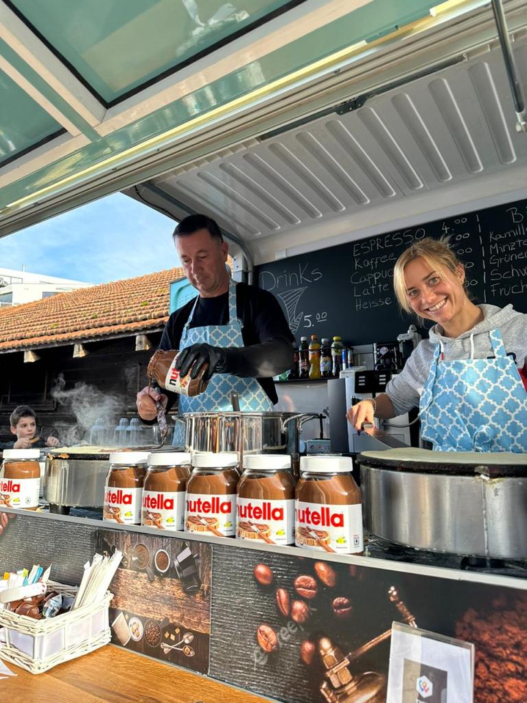 The Curb Cafe team smiling behind a row of Nutella jars